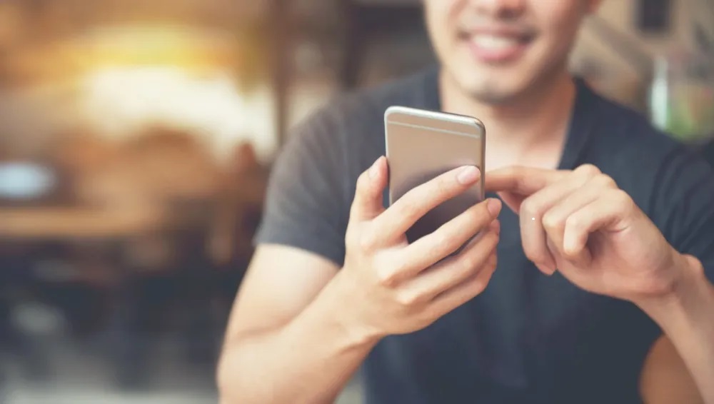 A man using a phone to book an online therapy